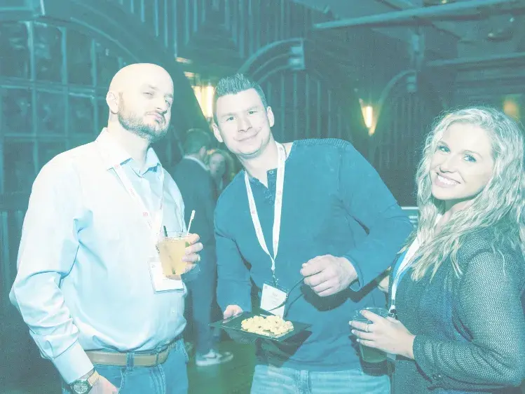 Two men and a woman posing for a photo