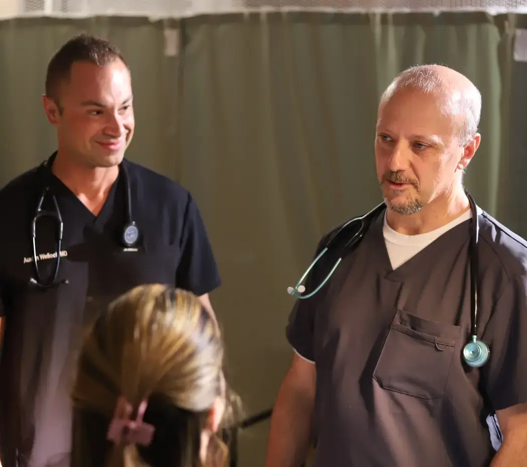 Two doctors talking to a younger patient